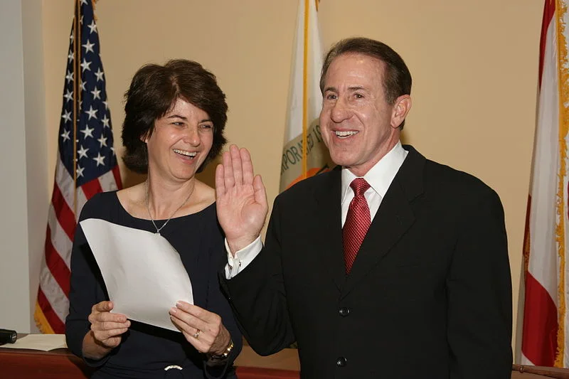 Gary Matzner smiling while being sworn in beside Evelyn Langlieb Greer.