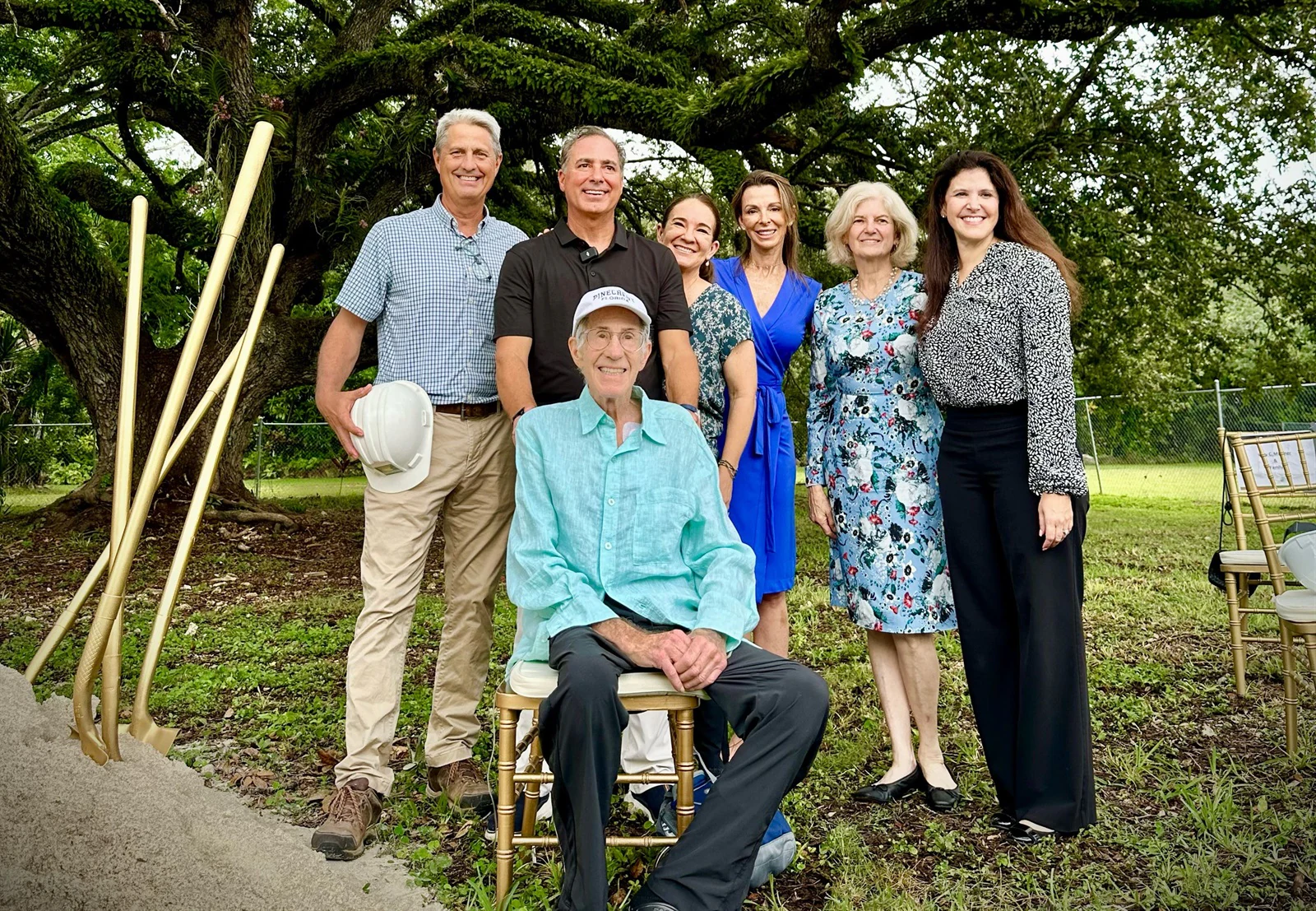 Gary Matzner, seated at far right in a turquoise shirt, joins family, Village officials, and neighbors at the July 2024 park groundbreaking.